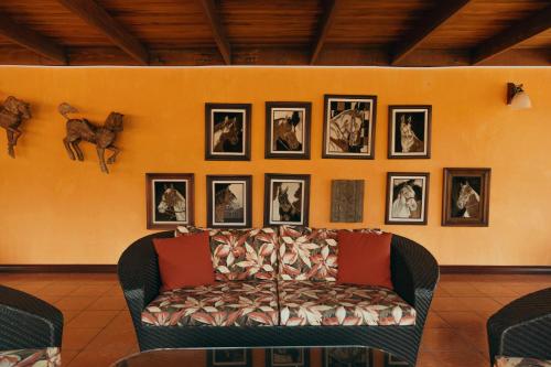 a living room with a couch and pictures on the wall at El Rodeo Estancia Boutique Hotel & Steakhouse in San José