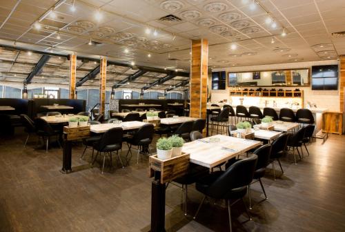 a restaurant with tables and chairs and a bar at Sandman Signature Lethbridge Lodge in Lethbridge