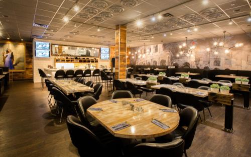 a restaurant with tables and chairs and a bar at Sandman Signature Lethbridge Lodge in Lethbridge