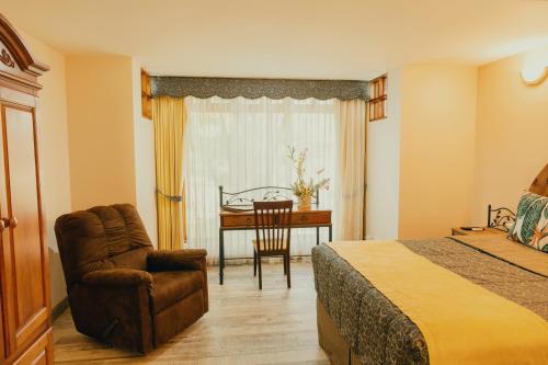 a bedroom with a bed and a chair and a desk at El Rodeo Estancia Boutique Hotel & Steakhouse in San José