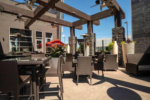 a patio with tables and chairs in a restaurant at Sandman Hotel & Suites Winnipeg Airport in Winnipeg