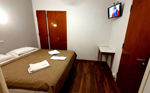 
a bedroom with a bed and a television at Hotel Tirol in Mar del Plata
