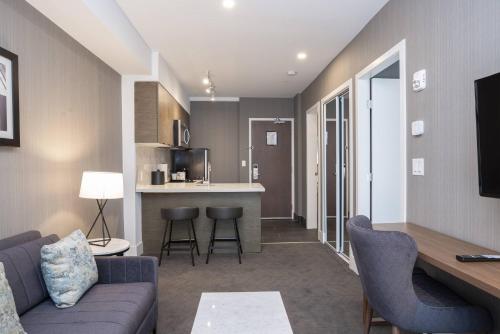 a living room with a couch and a kitchen at Sandman Signature Sherwood Park Hotel in Sherwood Park