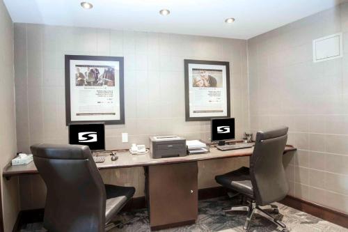 an office with two chairs and a desk with a printer at Sandman Hotel & Suites Prince George in Prince George