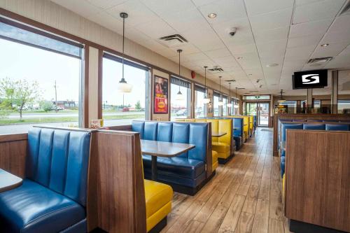 a restaurant with blue and yellow chairs and a table at Sandman Hotel & Suites Prince George in Prince George