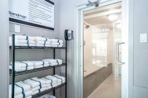 a bathroom with a rack of white towels at Sandman Hotel & Suites Prince George in Prince George