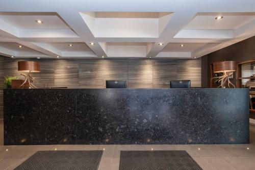 a hotel lobby with a black counter top at Sandman Hotel Vernon in Vernon