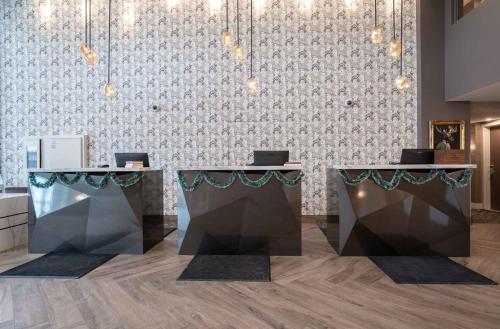 a lobby with two tables and a wall at Sandman Signature Ottawa Airport Hotel in Ottawa