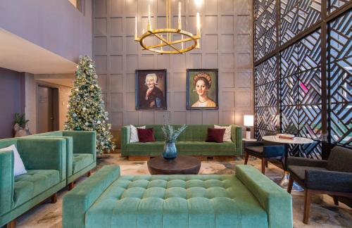a living room with green couches and a christmas tree at Sandman Signature Ottawa Airport Hotel in Ottawa