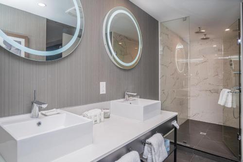a bathroom with a white sink and a mirror at Sandman Signature Ottawa Airport Hotel in Ottawa
