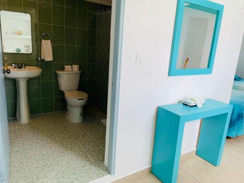 uma casa de banho com um WC, um lavatório e um espelho. em Habitación Amanecer Turquesa #2 em Isla Mujeres