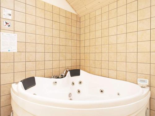 a white bath tub in a tiled bathroom at 12 person holiday home in Hals in Hals
