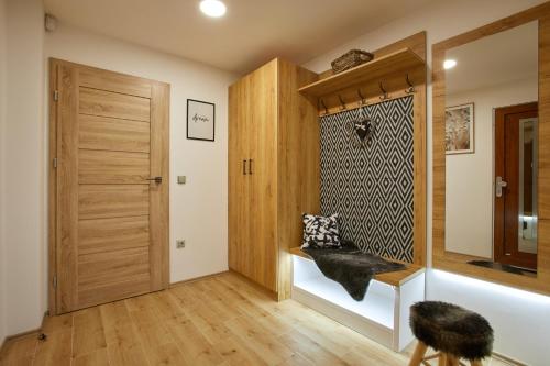 Pokój z drewnianymi drzwiami i ławką w obiekcie Apartmány Pustevny w mieście Prostřední Bečva