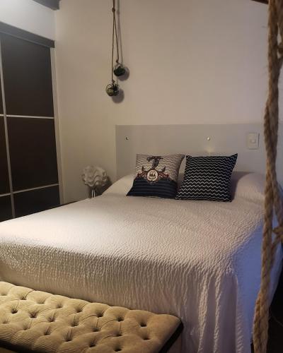a bed with black and white pillows on it at Flat 14 Pipa in Pipa