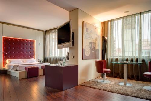 a hotel room with a bed and a tv at Carlemany Girona in Girona