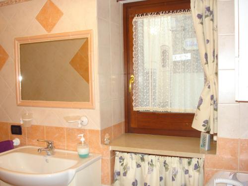 uma casa de banho com um lavatório e uma janela em La Casetta dei Sogni em Rieti