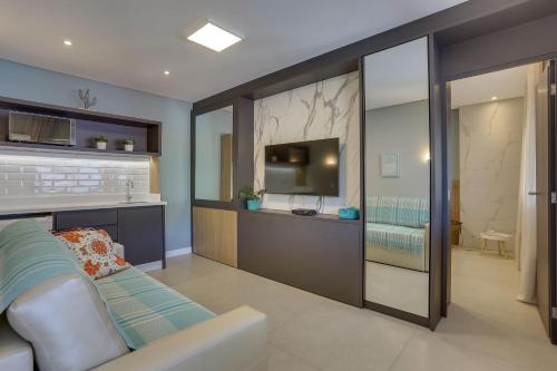 a living room with a couch and a tv at Hotel Sete Ilhas in Florianópolis