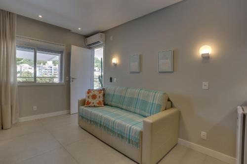 a living room with a couch and a window at Hotel Sete Ilhas in Florianópolis