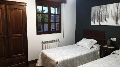 A bed or beds in a room at Casa Rural El Bellucu