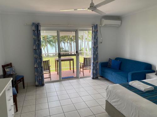 ein Wohnzimmer mit einem blauen Sofa und einem Tisch in der Unterkunft The Resort at Dolphin Heads in Mackay