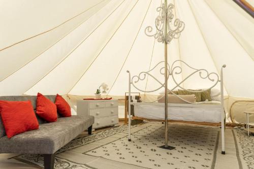 a bedroom with a tent with a bed and a couch at Leithfield Beach Holiday Park in Leithfield