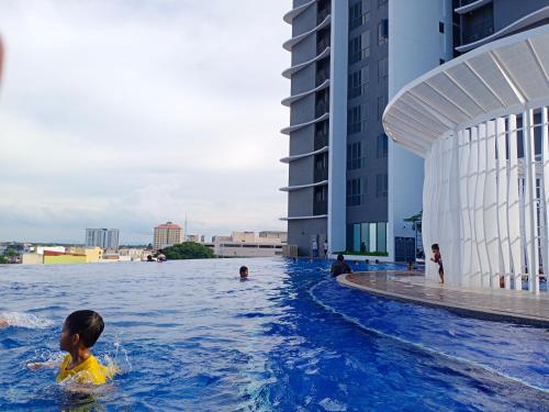 a child swimming in the water at a hotel at TROIKA DREAM HOME in Kota Bharu