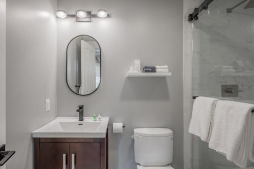 a bathroom with a toilet and a sink and a mirror at The George - Luxury Boutique Inn in Napa
