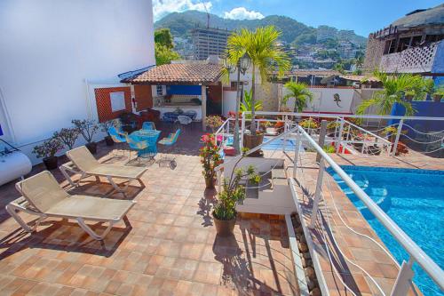 a balcony with chairs and a swimming pool on a building at La Iguana Vallarta LGBT - Romantic Zone - Party Clubbing Street in Puerto Vallarta