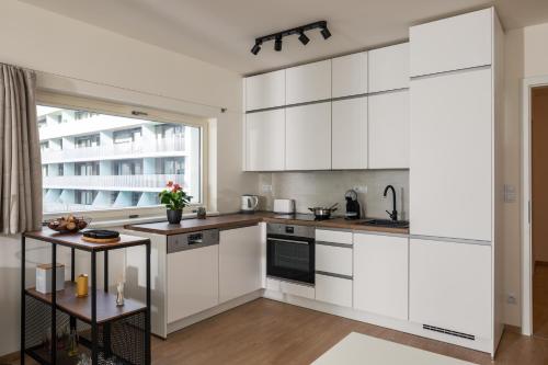 a kitchen with white cabinets and a large window at Prague Days - Exclusive Condo in Trendy Neighbourhood in Prague