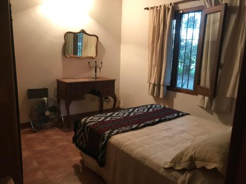 1 dormitorio con cama, escritorio y ventana en Baradero - La vida de campo a una hora del Obelisco! km142 R9 - las chapas casa de campo baradero en Baradero
