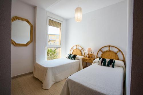 a bedroom with two beds and a window at Zurich 47 in Denia