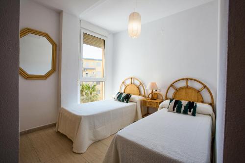 a bedroom with two beds and a window at Zurich 47 by homeprive in Denia