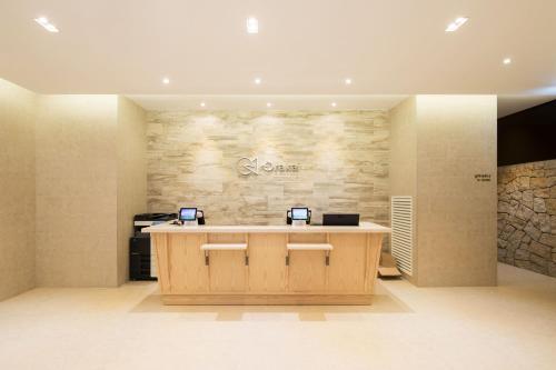 a lobby with a reception desk and a stone wall at Orakai Cheonggyesan Hotel, BW Premier Collection in Seoul