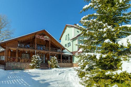 a large building with snow on the ground at Laguna in Slavske