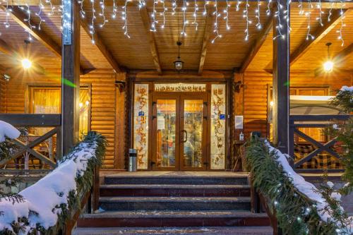 una puerta delantera de un edificio con nieve en las escaleras en Laguna en Slavske