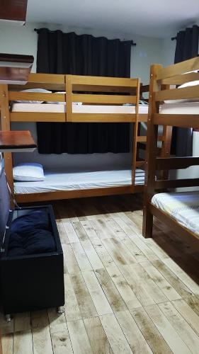 a room with two bunk beds on a wooden floor at Colina do Cristal in Santo Antônio do Pinhal