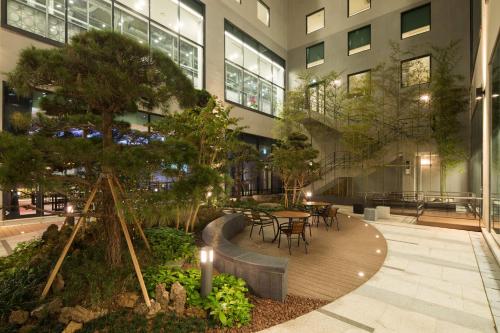 a building with a table and chairs in a courtyard at Orakai Cheonggyesan Hotel, BW Premier Collection in Seoul