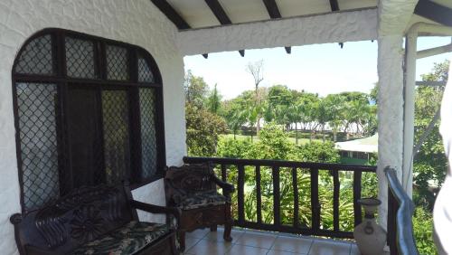 a porch with a chair and a balcony with a view at Hotel Arboleda in Quepos