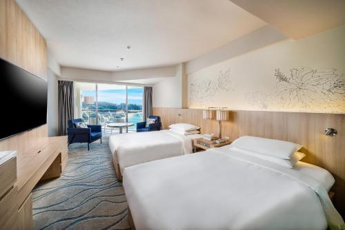 a hotel room with two beds and a television at Renaissance Okinawa Resort in Onna
