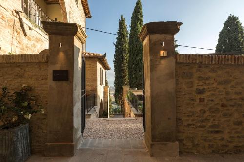 an entrance to a building with a stone fence at Rastrello in Panicale
