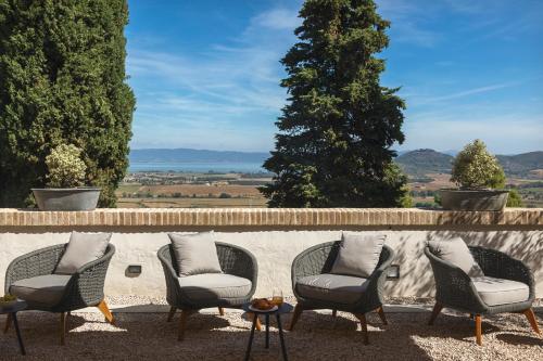 a group of chairs sitting next to a wall at Rastrello in Panicale