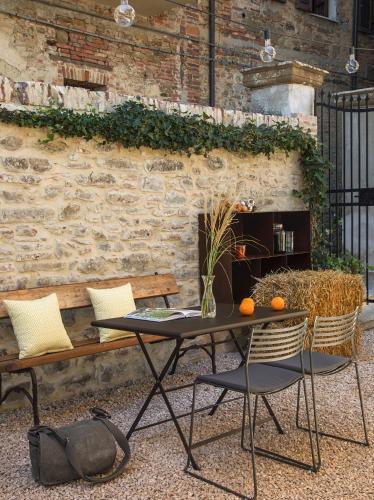 a table and chairs in front of a brick wall at Rastrello in Panicale