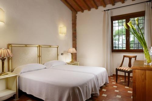 a bedroom with a white bed and a window at Fattoria San Lorenzo in Grosseto