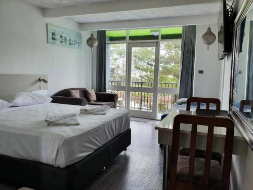 ein Schlafzimmer mit einem Bett und ein Wohnzimmer in der Unterkunft Le George Motel in Port Macquarie