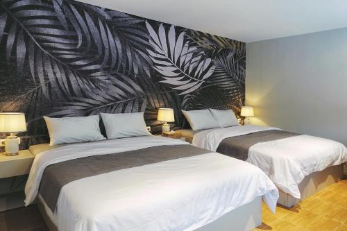 two beds in a hotel room with a wall mural at Villa Stella By The Villas 100 in Bogor