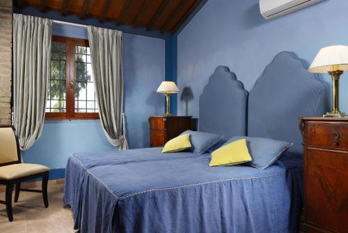 a blue bedroom with a bed and a chair at Fattoria San Lorenzo in Grosseto