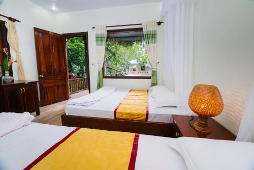 En eller flere senger på et rom på Mỹ Khánh Resort