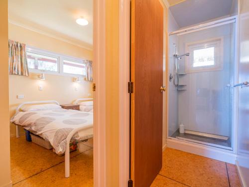 a small room with a bed and a window at Poppy's Beach House - Beachfront Whangapoua Home in Whangapoua