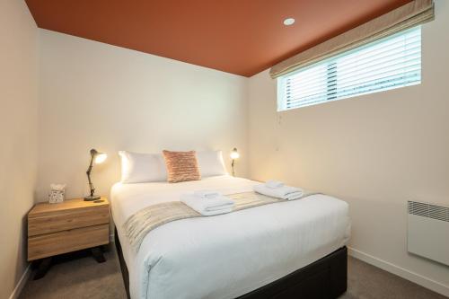 niewielka sypialnia z łóżkiem i oknem w obiekcie The Nest Central Christchurch w mieście Christchurch