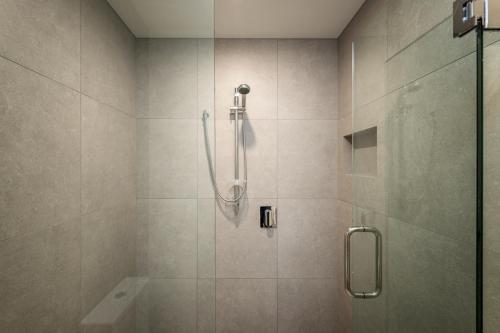 a bathroom with a shower with a glass door at The Nest Central Christchurch in Christchurch